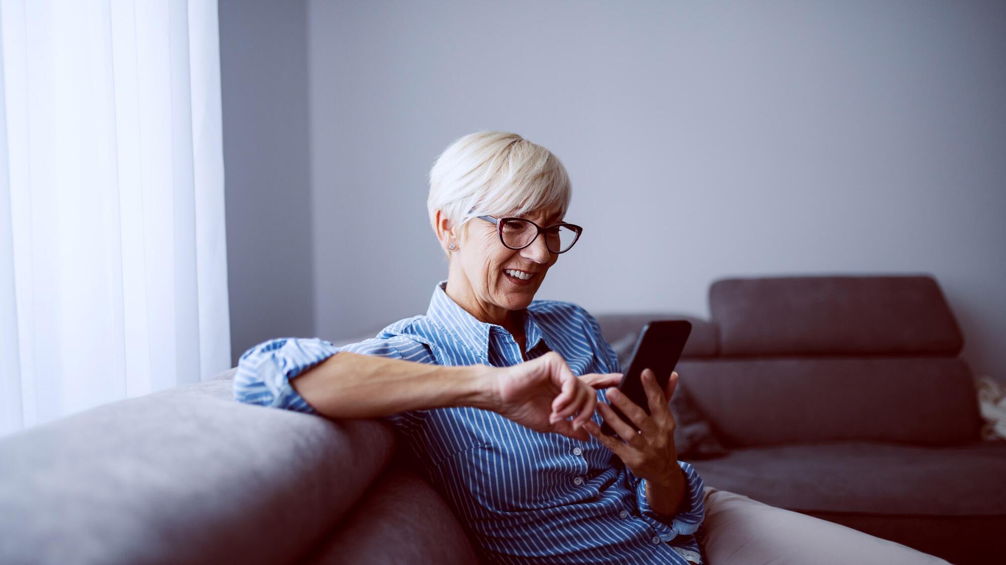 Woman in glasses using phone touchscreen