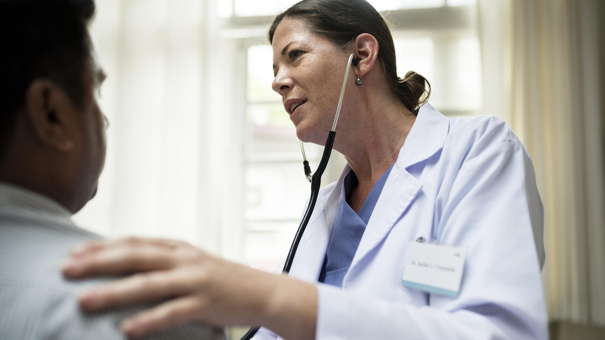 Female doctor checking a patient, wearing a stethoscope 